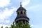 Sculptured tower with weather vane, dome, and pillars