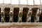 Sculptures of human faces and heads of animals and monsters on the wooden corbels of a medieval house in Mirepoix