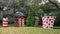 Sculptures of large Christmas gifts with bows and an undecorated Christmas tree before a mansion in Highland Park, Dallas, Texas