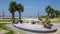 Sculptures of a man and a woman sitting near a fireplace on the seashore and eating rice surrounded by palm trees on the South Kor