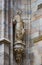 Sculptures of saints and martyrs decorating the Cathedral of Milan Duomo di Milano are shot close-up.