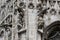 Sculptures of saints and martyrs decorating the Cathedral of Milan Duomo di Milano are shot close-up.