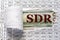 SDR is the acronym behind torn office paper with numbers