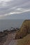 The Sea Arch below Maw Skelly Headland and Sea Cliffs on and above the narrow Shingle Beach and rocky outcrops.