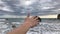 Sea background near the rocks. womans hand shows away into the sea