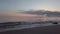 Sea backwash at sunset seen from shoreline with beautiful pastel-colored sky