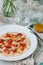 Sea bass carpaccio with baked strawberries and citrus dressing.