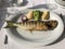 Sea bass, lemon, onion, broccoli and potato on a single plate