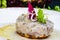 Sea bass tartare with toasted bread on a white plate