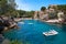 Sea bay a beautiful summer day blue clear water and granite stones. Boats above coral reef. Spain.