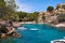 Sea bay a beautiful summer day blue clear water and granite stones. Boats above coral reef. Spain.