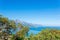 Sea bay with a distant mountainous coast, view of mount Tahtali Lycian Olympus through the branches of trees in Antalya province