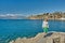 Sea bay near old city in Turkish Antalya and lonely young woman on ruins of old pier in early spring on sunny day.