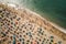 Sea beach with colorful umbrellas and relaxing people, top view. Generative AI