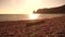 Sea beach horizon. Sea waves with soft, foamy waters washing multicolored pebbles on a beach during sunset. Nobody