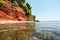 Sea beach with red ground and pine trees in Greece, Halkidiki