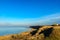 Sea beach with small rocky lagoon and coastal grass. Deep blue sky. Russia Azov sea