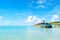 Sea beach with wooden shelter on sunny day in antigua. Pier in turquoise water on blue sky background. Summer vacation on caribbea