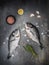 Sea bream - dorado sea fish, thyme, lemon, garlic and Himalayan salt on dark vintage background.