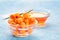 Sea-buckthorn berries in bowl and natural honey or sea buckthorn oil on blue background