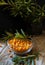 Sea buckthorn berries in the glass bawl with leaves on the wooden background