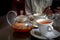 Sea buckthorn tea in glass teapot. Herbal tea is poured into white cups from glass teapot.