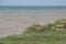 Sea cliffs of boulder clay in front of beaches. Clay Cliffs and Beach with Blue Sky and Water. Precipice coast near the sea.