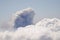 Sea of clouds and smoke plume from a volcanic eruption.