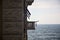 Sea on a cloudy day framed by a facade with a balcony