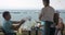 On the sea coast of city Perea, Greece a young family sits in cafe