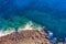 Sea coast on rocky beaches with turquoise water waves, aerial view