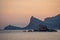 Sea coast with rocky cliffs. Seashore near a mountain with rocks and small waves.