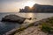 Sea coast with rocky cliffs. Seashore near a mountain with rocks and small waves.