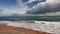 Sea coast, sandy beach, clear day, white clouds in the blue sky.