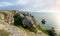 Sea coast with steep textured limestone rocks and shipwrecked ship