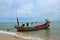 Sea going fishing vessel boat with outboard motor parked on beach in Pattani village Thailand