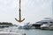 Sea Golden anchor on the background of blured yachts in the sea in the sun