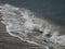 The Sea green wave runs over the smooth sandy beach, leaving a white foam on the sand