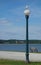 Sea gull perched on lamp post against bright blue sky