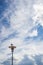 Sea gull sitting on a lamp post in front of cloudy sky