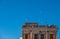 Sea gulls and pigeons fly over the roof of a derelict building against the blue sky in Aegina, Greece