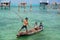 Sea Gypsy Kids on their sampan with their house on stilts in the