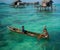 Sea Gypsy Kids on their sampan with their house on stilts in the