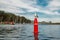 Sea Harbor and Seagull Sitting on the Buoy Against Cloudy Blue Sky