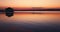 Sea horizon and color sunset over bungalow villa over wooden pier in water