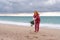 Sea Lady in plaid shirt with a christmas tree in her hands enjoys beach. Coastal area. Christmas, New Year holidays
