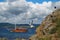 Sea landscape with rock, sky, seagull and boat.