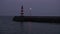 Sea lighthouse and pier at night