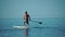 Sea man sup. Asian athlete man swimming in sea and paddleboarding at summer sunset. Healthy strong male enjoy outdoor