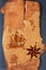 Sea map with illustrations of sailing vessel and compass rose on the order of antiquities on natural wooden background from birch